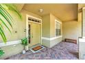 Inviting covered front porch with brick pavers, bench seating, and a view of the front door at 11808 Holly Crest Ln, Riverview, FL 33569