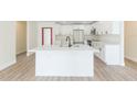 A modern kitchen featuring white cabinetry, stainless steel appliances, a large island, and stylish countertops at 12910 Longcrest Dr, Riverview, FL 33579