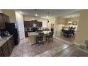 Open kitchen and dining area with a granite island, stainless appliances, and tile floors at 13421 Lake Monroe Pl, Riverview, FL 33579