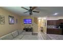 Cozy living room featuring a plush sectional couch, television, and a view to the kitchen at 13421 Lake Monroe Pl, Riverview, FL 33579