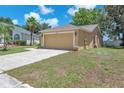 Side view of a single story home with a two car garage and well manicured lawn at 13437 Beechberry Dr, Riverview, FL 33579