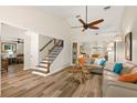 Bright living room with vaulted ceilings, wood floors, comfortable seating, and staircase at 13598 Park Blvd, Seminole, FL 33776