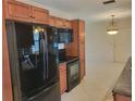Spacious kitchen with stainless steel appliances, tile floors, and dark countertops at 13725 Bermuda Dr, Seminole, FL 33776