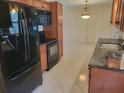 Kitchen featuring stainless steel appliances, dark countertops, and tile flooring at 13725 Bermuda Dr, Seminole, FL 33776
