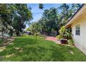 Expansive backyard featuring lush green grass and mature trees, perfect for outdoor enjoyment at 1720 Chrysler Ave, Sarasota, FL 34234