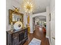Inviting entryway featuring dark hardwood floors, decorative mirror and light fixture, and an arched opening at 18003 Arbor Crest Dr, Tampa, FL 33647