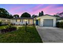 Charming home at dusk with a well-maintained lawn, beautiful landscaping, and inviting curb appeal at 1809 Elmwood Dr, Oldsmar, FL 34677