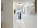 Hallway featuring neutral colors, tile flooring, decorative art and archway at 18107 Canal Pointe St, Tampa, FL 33647