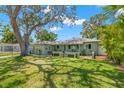 Inviting home with lush green lawn, large shade tree, tidy landscaping, and classic painted exterior at 1827 Oregon Ne Ave, St Petersburg, FL 33703