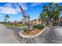 Aspen Circle community entrance with American flag, mature trees, landscaping, and pond at 224 Aspen Cir # 224, Seminole, FL 33777