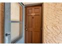 Unit 224's solid wood front door with security screen and textured stucco walls at 224 Aspen Cir # 224, Seminole, FL 33777