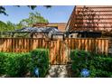 Inviting entrance with a well-maintained wooden fence and lush green landscaping at 2706 11Th Ct, Palm Harbor, FL 34684