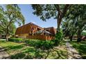 Exterior view of a townhome with a well-kept lawn, a fence and beautiful trees at 2706 11Th Ct, Palm Harbor, FL 34684