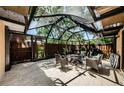Enclosed patio featuring comfortable seating, a fire pit, and views of lush greenery at 2706 11Th Ct, Palm Harbor, FL 34684