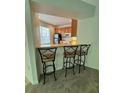 View of kitchenette featuring breakfast bar with stools, wood cabinets, and stainless steel appliances at 27653 Pleasure Ride Loop, Wesley Chapel, FL 33544