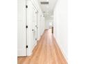 Bright hallway with neutral walls and wood floors featuring multiple doors leading to various rooms in the home at 3002 W Abdella St, Tampa, FL 33607
