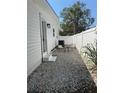 Seating area outside the back door with white privacy fence and rock landscaping at 3008 E 38Th Ave, Tampa, FL 33610