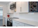 Stylish kitchen with white cabinets, stainless steel appliances, and modern lighting at 3008 E 38Th Ave, Tampa, FL 33610