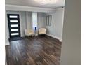 Open living room with dark wood floors, bright white paint, and a decorative light fixture at 3008 E 38Th Ave, Tampa, FL 33610