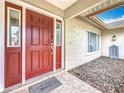 Inviting front entrance features a red door with sidelights and a 'Be Our Guest' welcome mat at 3093 Hillside Ln, Safety Harbor, FL 34695