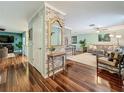 Open-concept living room with hardwood floors, brick accent wall, and ample natural light at 3093 Hillside Ln, Safety Harbor, FL 34695