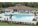Community pool area featuring ample lounge seating and well-maintained landscaping at 3810 Romano Busciglio St, Tampa, FL 33619