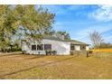 The exterior features a home with a white facade, dark window trim, complemented by a well-kept yard with lush greenery at 5526 Southernview Dr, Zephyrhills, FL 33541