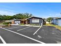 Single-story building with a parking lot, bright yellow door, and covered patio area at 601 Patricia Ave # A, Dunedin, FL 34698