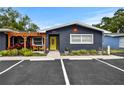 Beautifully landscaped single-story home featuring a bright yellow door and covered patio space at 601 Patricia Ave, Dunedin, FL 34698