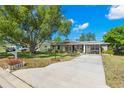 Charming single story home featuring a well-manicured lawn with mature trees and a concrete driveway at 707 24Th Sw St, Largo, FL 33770