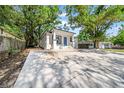 Charming bungalow with a blue door, surrounded by mature trees and a spacious driveway at 8504 N 17Th St, Tampa, FL 33604
