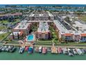 Stunning aerial view of the condo complex with a pool, marina, and lush landscaping at 8931 Blind Pass Rd # 360, St Pete Beach, FL 33706