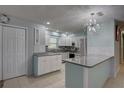 Bright kitchen with granite countertops, stainless steel appliances, and a stylish modern chandelier at 9240 53Rd N Way, Pinellas Park, FL 33782