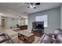 Cozy living room with plush leather seating and a large window providing natural light and ceiling fan at 9240 53Rd N Way, Pinellas Park, FL 33782