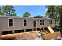 New single-story home featuring a neutral exterior, white-trimmed windows, and a front door, set against a bright blue sky at 10040 Lake Dr, Weeki Wachee, FL 34613