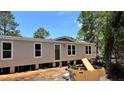 New single-story home featuring a neutral exterior, white-trimmed windows, and a front door, set against a bright blue sky at 10040 Lake Dr, Weeki Wachee, FL 34613
