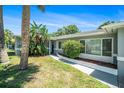 Inviting home entrance with lush tropical landscaping and a charming walkway at 105 N Comet Ave, Clearwater, FL 33765