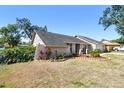 Side view of a charming house featuring a well-maintained lawn and garden at 1111 Lakemont Dr, Valrico, FL 33594