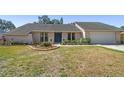 Charming single-story home with a vibrant blue front door and landscaped garden at 1111 Lakemont Dr, Valrico, FL 33594