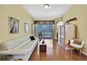 Bright living room with hardwood floors and a sliding glass door that leads to the lanai at 12012 Cromwell Way, Spring Hill, FL 34609
