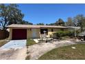 Charming single-story home with mature trees, a red garage door, and a well-lit entrance at 12049 132Nd Ave, Seminole, FL 33778