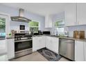 Well-equipped kitchen featuring stainless steel appliances, white cabinetry, and a view of the patio at 1210 Bay Palm Blvd, Indian Rocks Beach, FL 33785