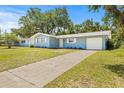 A single-story home with a well-manicured lawn and a long driveway to the attached one-car garage at 1459 Joel Ln, Clearwater, FL 33755