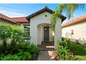 The front entry features an arched entryway with lovely landscaping and a walkway to the driveway at 16913 Anchor Root St, Wimauma, FL 33598