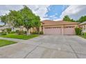 Lovely single-story home showcases a three-car garage, lush landscaping, and a concrete driveway beneath a sunny sky at 18444 Eastwyck Dr, Tampa, FL 33647