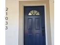Detailed view of the navy blue front door with classic panel design and decorative glass insert at 21033 Market St, Dade City, FL 33523