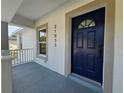 Close-up of the front door with navy blue color, house number, and a charming covered porch at 21033 Market St, Dade City, FL 33523