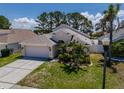 Beautiful single-Gathering home with a two-car garage, well-maintained lawn, and inviting landscaping at 2614 Hawk Roost Ct, Holiday, FL 34691