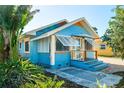 Attractive exterior shot showcasing the bright blue of this home, with tropical landscaping at 3108 Dupont S St, Gulfport, FL 33707