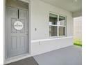 Inviting entryway with a gray front door and a decorative 'Welcome' sign at 33524 Elm Hill Br, Wesley Chapel, FL 33545